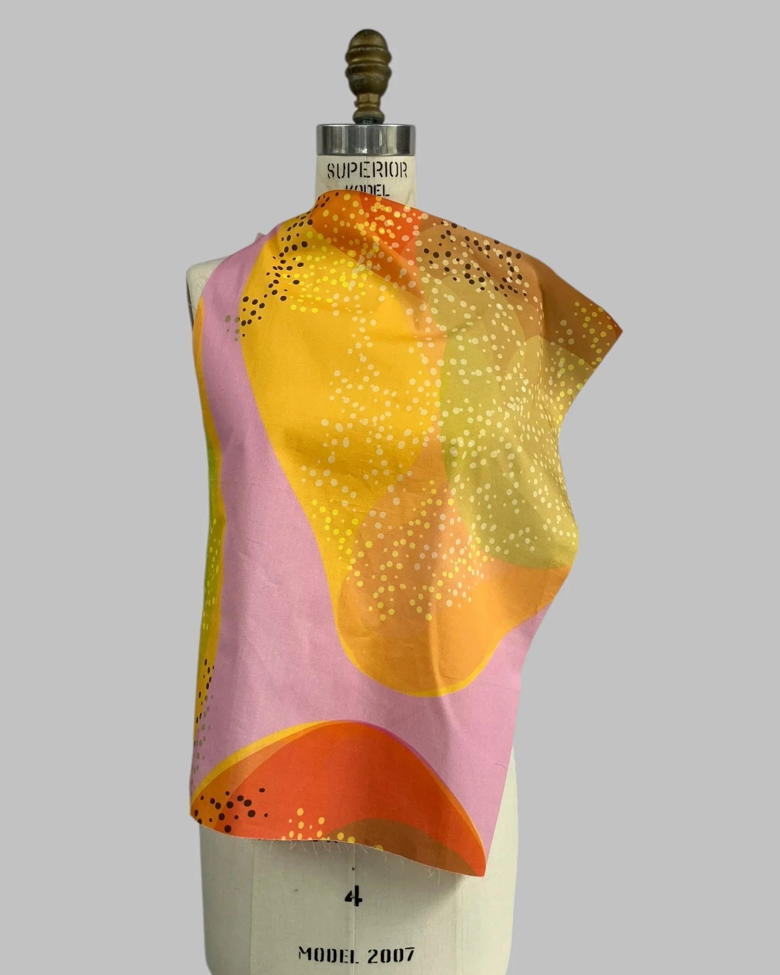 Bright mango and pink abstract Hawaiian print fabric draped on a dress form