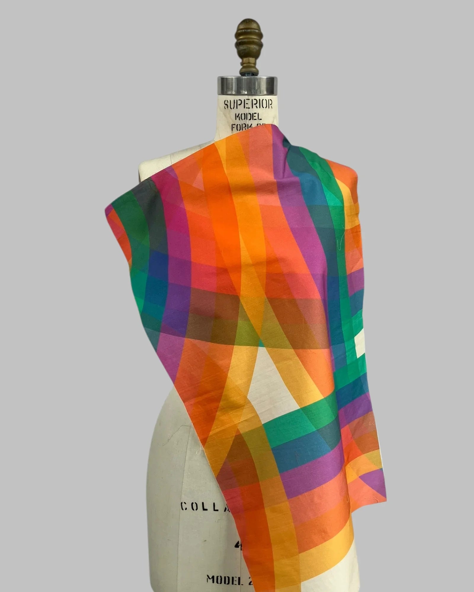 Colorful rainbow plaid fabric swatch draped on dress form, modern Hawaiian textile