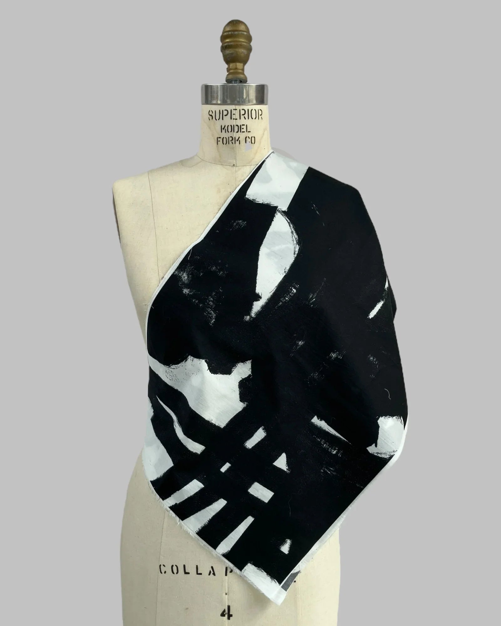 Black and white abstract print fabric swatch draped on dress form