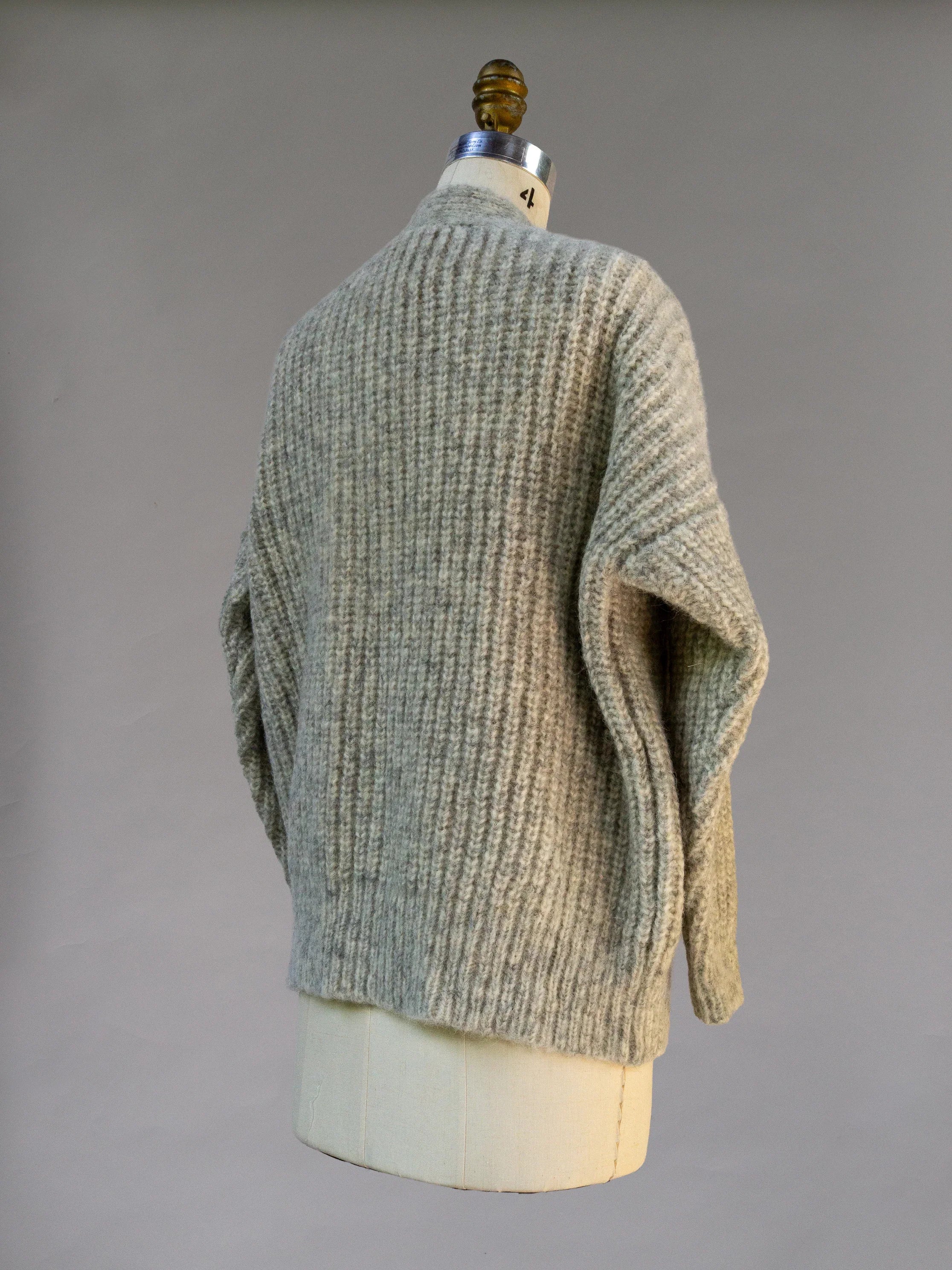 Back view of a gray textured knit sweater on dress form, cozy winter clothing
