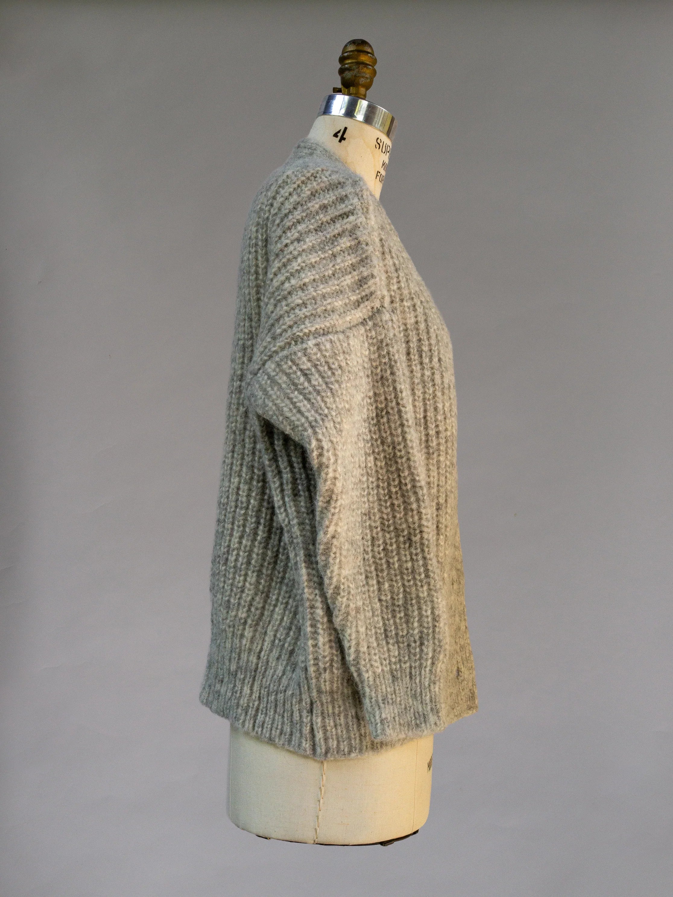 Cozy ribbed knit grey sweater displayed on a mannequin side view