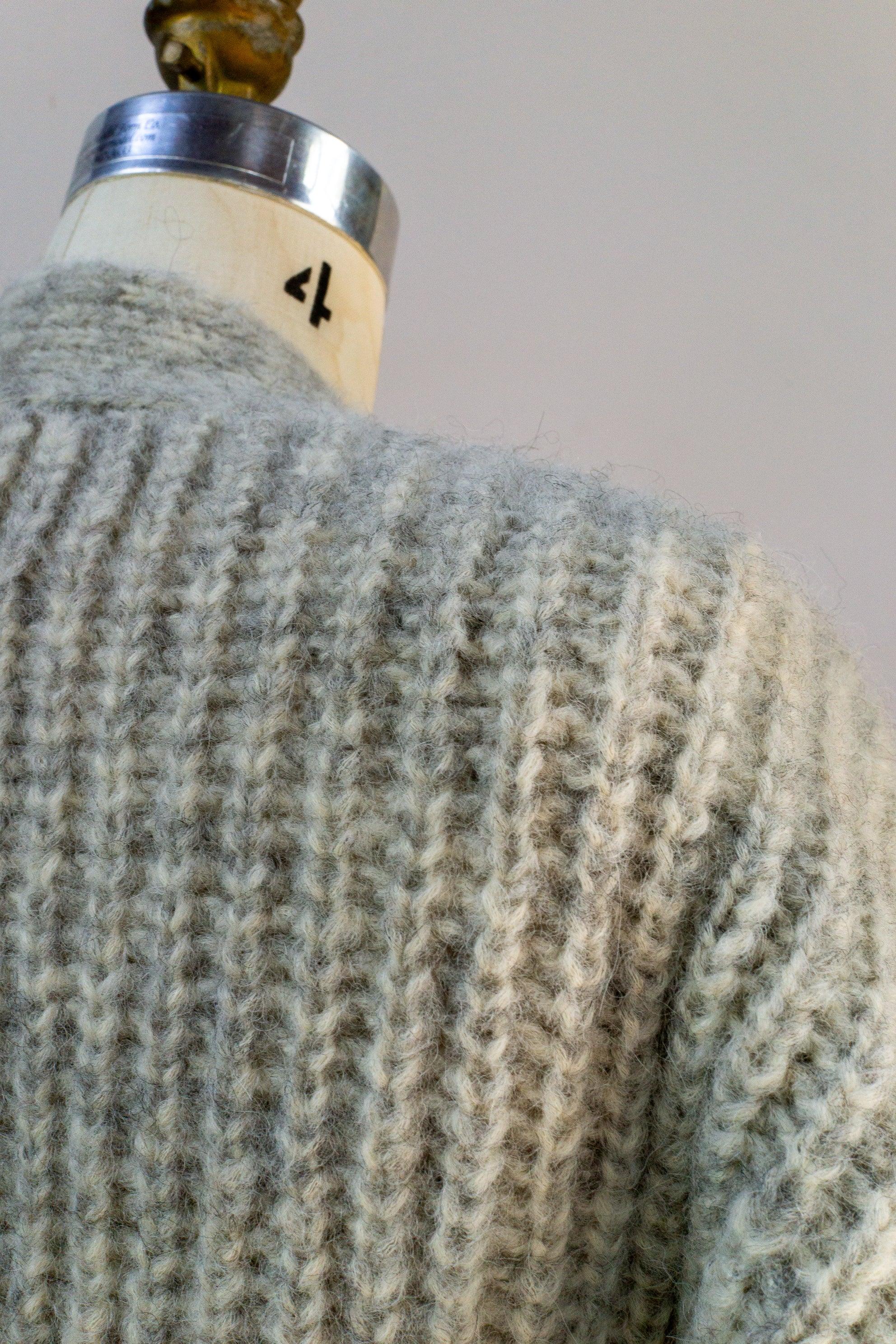Close-up of a textured grey knit sweater on a mannequin