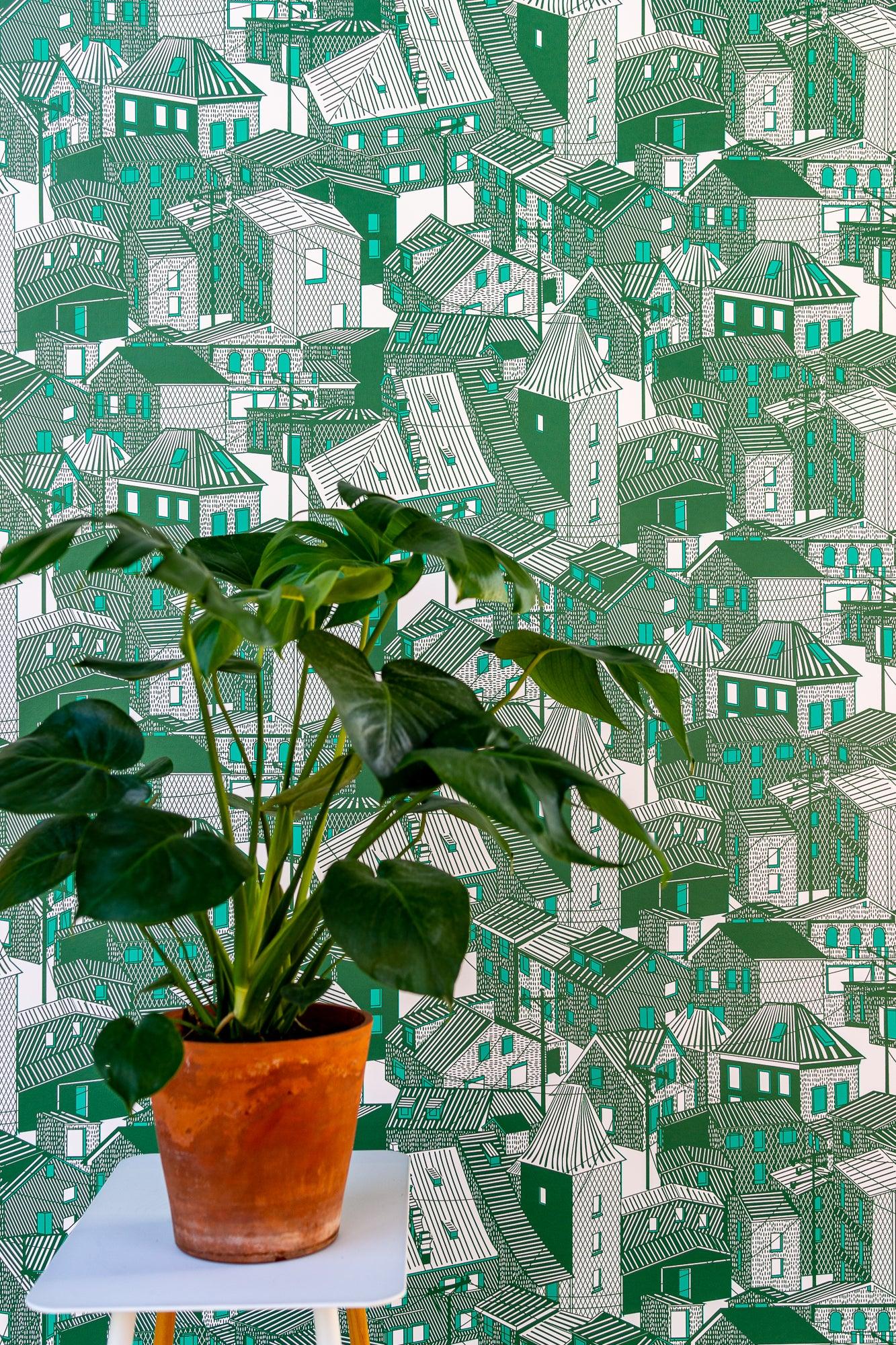 Green house-print wallpaper with potted plant on white table in foreground