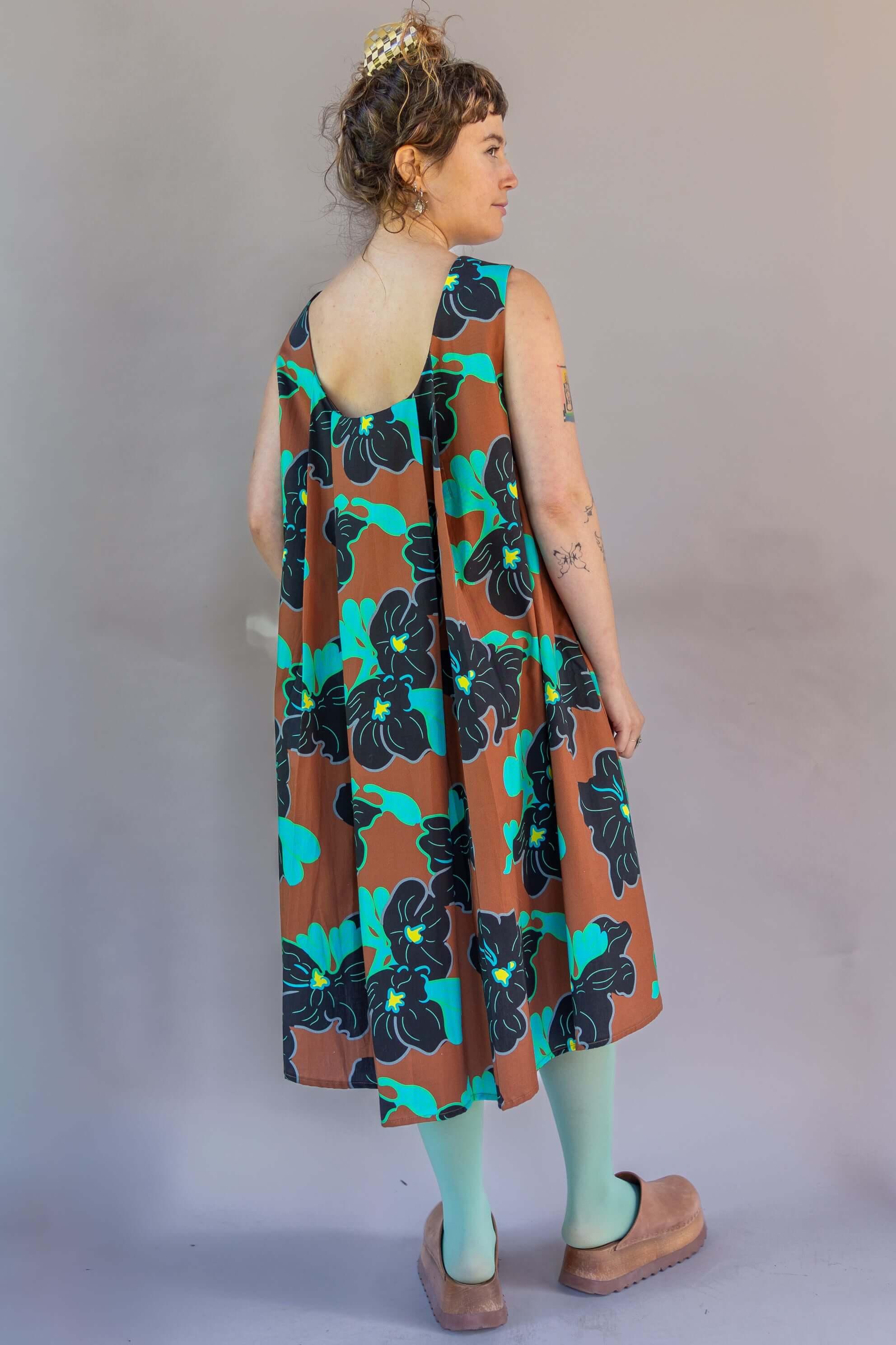 Model wearing a Watteau Dress 1961 Chestnut with iconic pleating and Hawaiian floral print.